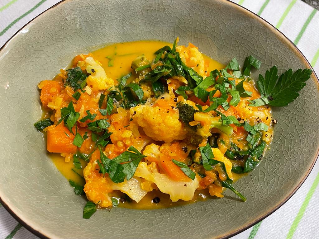 Blumenkohl-Brokkoli-Curry mit Kürbis und Spinat im Teller