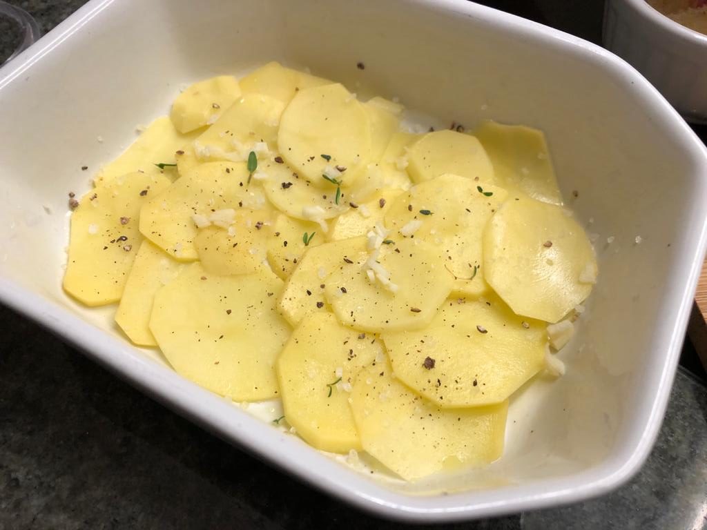 erste Lage des Kartoffelgratins mit Knoblauch und Thymian