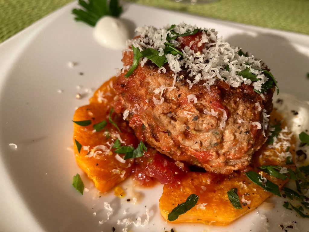 Hackbällchen mit Kürbis und Tomate im Teller