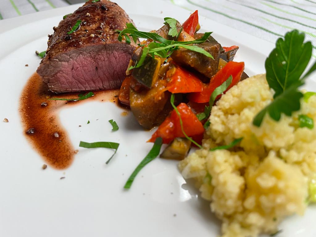 Lammfilet mit Ratatouille und Couscous im Teller