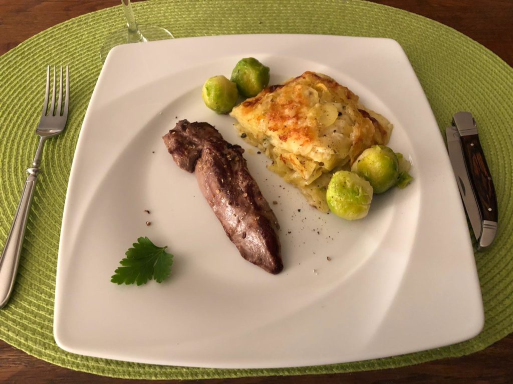 Rehfilet mit Kartoffelgratin und Rosenkohl ist auf dem Tisch