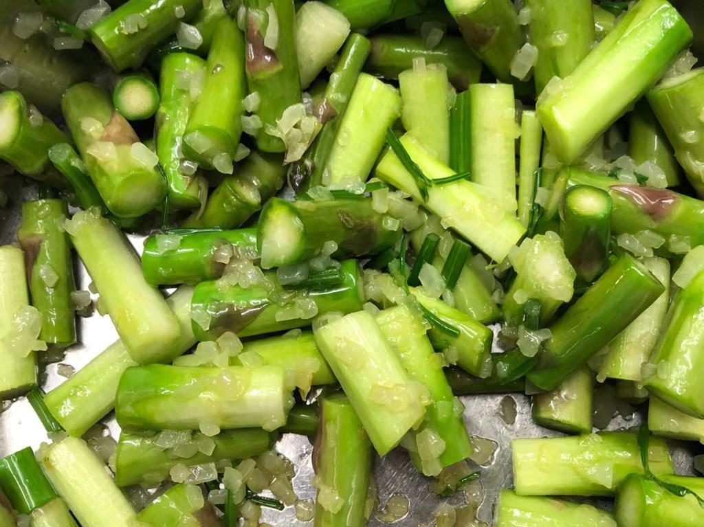 Stücke vom grünen Spargel in Butter und Zwiebeln