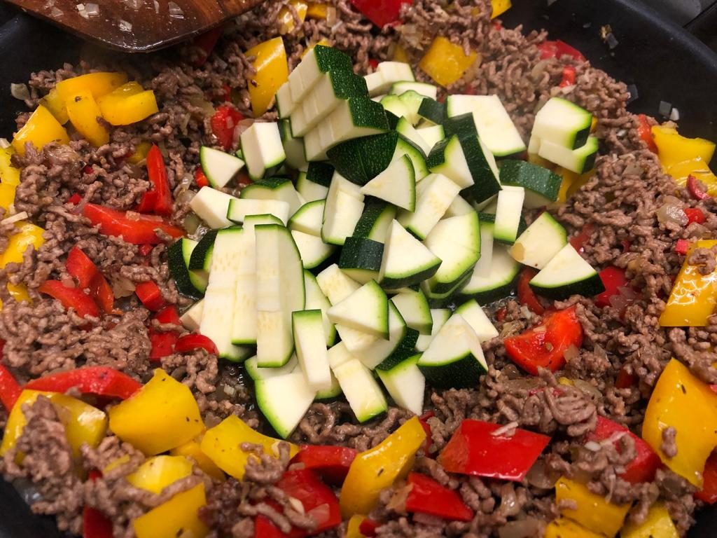 Zucchini zum Hack und Paprika geben