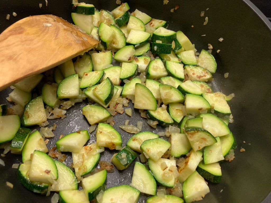 zwiebeln, Knoblauch und Zucchini anbraten