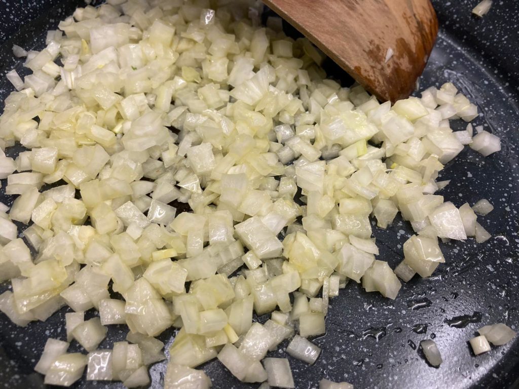 Zwiebeln und Knoblauch in Olivenöl glasig werden lasssen